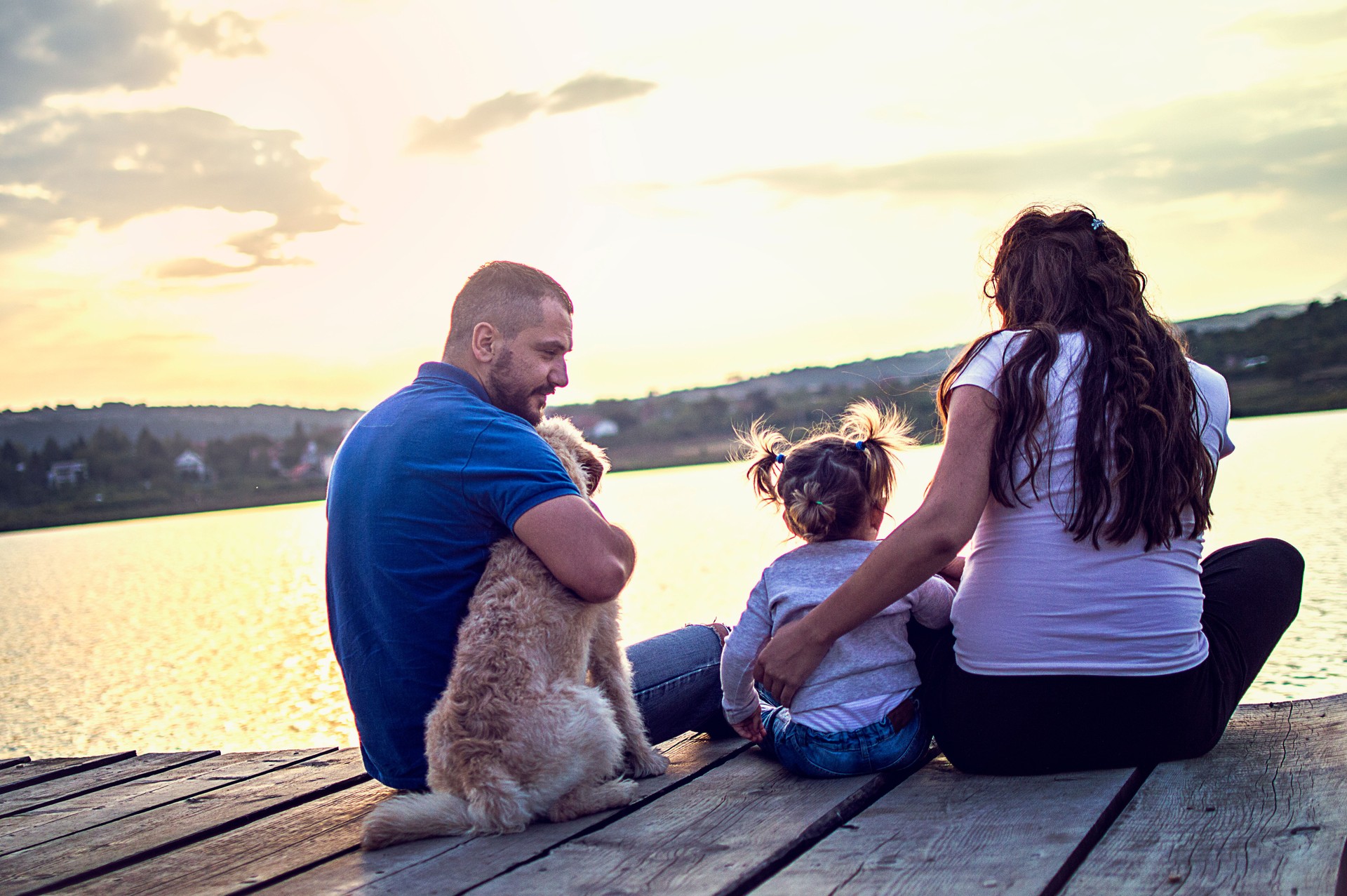 Filha feliz com pais e cachorro no píer Filha feliz com pais e cachorro no píer